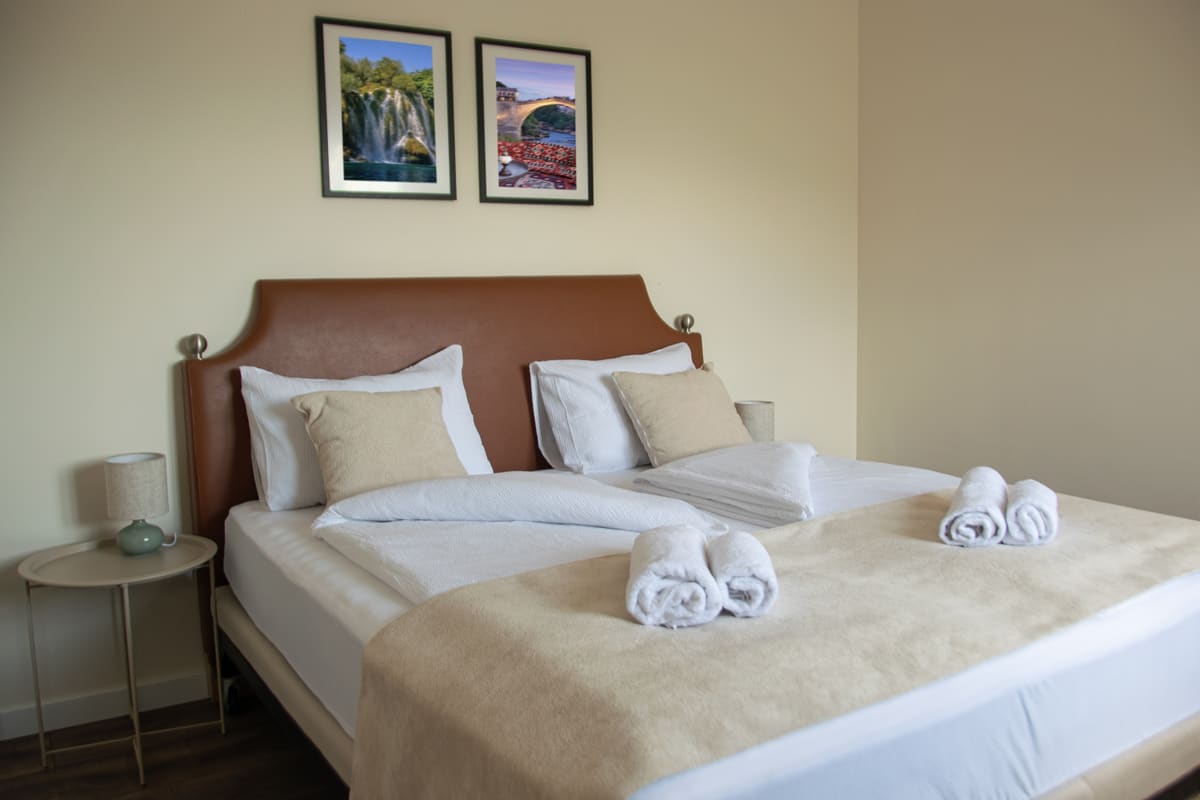 Cozy Room interior — Mediterranean king-size bed setup with warm olive tones